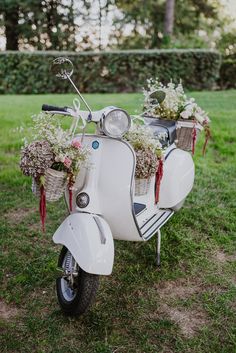 a white scooter with flowers in the basket