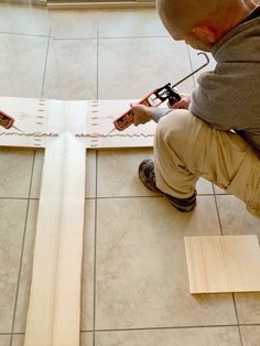 a young boy is working on some wooden pieces with glue and wood shavings