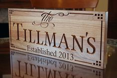 a wooden sign that says the tillman's established 2013 is on a table