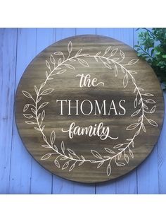 a wooden sign that says, the thomas family with leaves around it on a blue background