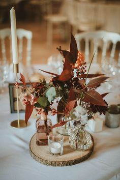 an arrangement of flowers and candles on a table