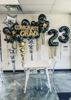 black and gold confetti grand balloons in the middle of a room