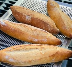 three loaves of bread sitting on top of a grill