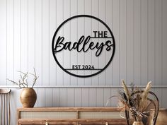 there is a sign that says the badley's on the wall next to some vases