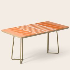 an orange table with metal legs and a white top on a grey background, it is designed in the shape of a rectangle