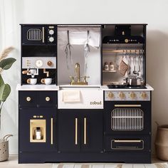 a black and white kitchen with gold accents on the stove, oven, sink and cabinets