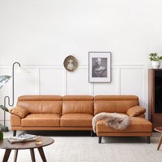 a brown leather couch sitting in a living room next to a table