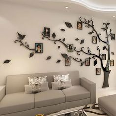 a living room with a couch, coffee table and tree wall art on the wall