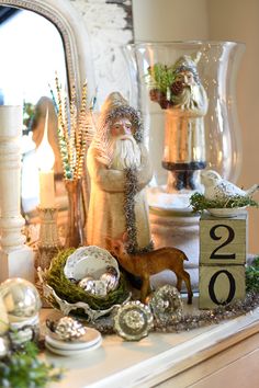 a mantel decorated with ornaments, candles and figurines on top of it