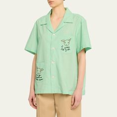 Bode "See You At The Barn" button-front shirt features embroidered details throughout  Notched collar Short sleeves Front patch pockets  Hip length  Relaxed fit  Cotton Imported Short Sleeve Embroidered Shirt For Work, Embroidered Collared Tops For Work, Embroidered Cotton Camp Collar Tops, Green Button-up Top With Patch Pockets, Collared Tops With Patch Pockets, Embroidered Cotton Tops With Camp Collar, Collared Tops With Patch Pockets For Daywear, Embroidered Camp Collar Top With Relaxed Fit, Embroidered Spread Collar Top For Work