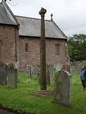 an old church and graveyard with a person standing in the grass