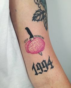 a person with a tattoo on their arm has a knife and brain in the middle