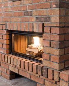 a brick fireplace with a lit fire in it