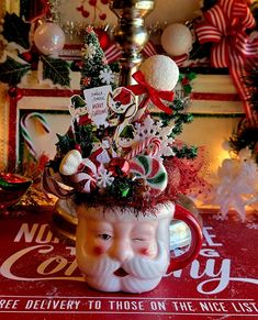 a coffee mug decorated with candy canes, candies and christmas decorations sits on a table