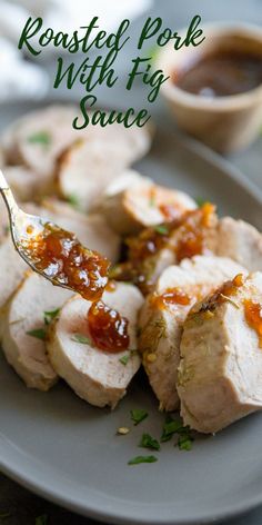 pork with fig sauce is on a plate and has a fork stuck in the meat