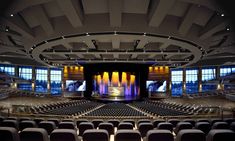 an empty auditorium with rows of seats and large screen