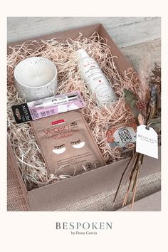 an open box filled with personal care items on top of a table next to a cup