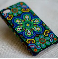 the colorful beaded phone case is sitting on the table