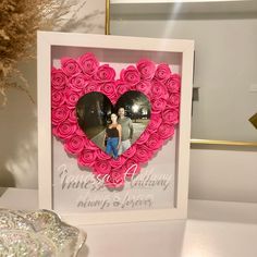 a heart shaped photo frame with pink roses in it