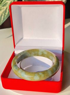 This Jade bangle outer is rounded and and flatten on the inside by hand. This jade bangle untreated Type-A jadeite jade. It has been polished on the inside and outside. The photos have not been altered or changed at all. *Bangle Shape: Flat Inner, Round Outer *Color: Icy Cloudy Transparent Apple Green and Blue Lavender *Luster: Vitreous *Transparency: Translucent *Inside Width: 58.6 mm *Bangle Width: 14.2 mm *Outer Width: 75.7 mm *Weight: 68 Grams *Size: Medium *Texture: Fine and Smooth *Free st Jade Bangle Jewelry Gift, Jade Bangle Jewelry For Gifts, Jade Gemstone Bangle Jewelry, Handmade Round Jade Bangle, Jade Gemstone Bangle Bracelet, Green Jade Bracelet For Wedding, Jade Gemstone Bangle As Gift, Green Bangle With Natural Stones For Gift, Green Gemstone Bangle For Anniversary