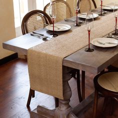 a dining table set with place settings and plates on it, ready to be served