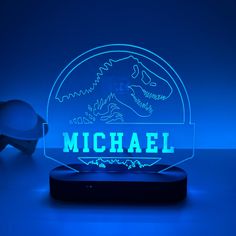 a neon sign that says michael on it with a blue background and a pair of glasses in the foreground