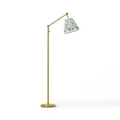 a gold floor lamp with a white shade on the top and bottom, in front of a white background