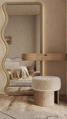 a mirror that is on the wall above a stool in a room with wooden floors