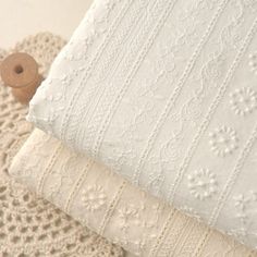 two white crocheted pillows sitting next to each other