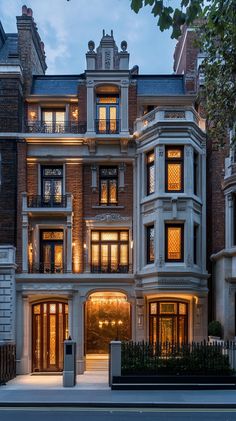 a large building with lots of windows and lights on it's front entrance at night