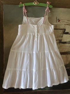 "This classic formal white cotton dress for girls is the perfect outfit for any summer special occasion. The dress is made of lightweight cotton in a unique wrinkled texture resembling gauze. The dress is fully lined with solid cotton underneath. This ensures comfort for your toddler so that the material is soft against her skin. The material is lightweight, making it perfect as a summer or spring dress. The ruffled skirt is giving to dress Victorian look. This dress has a slim fit on bodice wit White Cotton Dress With Gathered Skirt, Vintage White Cotton Sundress, Vintage White Cotton Dress With Ruffles, White Vintage Cotton Sundress, White Tiered Cotton Mini Dress, Toddler Baptism, Tank Top Girl, Thrift Clothes, Top Girl