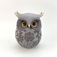 an owl figurine sitting on top of a white table