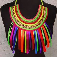 a woman's torso wearing a multicolored necklace with fringes on it