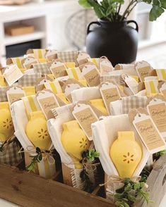 there are many small yellow items in the wooden box with tags on them and tied to burlap bags