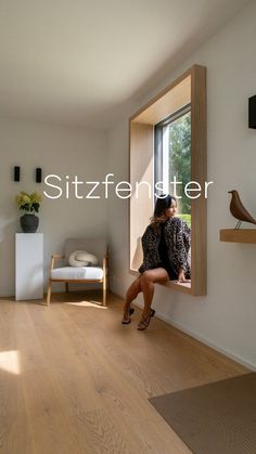 a woman sitting on a window sill looking out the window