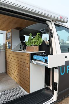 an open van door with a plant in the back