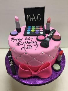 a birthday cake decorated with makeup and cosmetics on top of a purple tableclothed plate