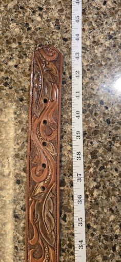 a ruler is sitting on a counter next to a piece of leather that has been carved into it