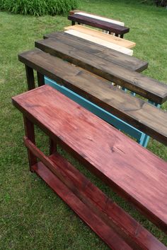 several wooden benches lined up in the grass