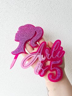 there is a hand that has some type of cake topper on it and the word are 25