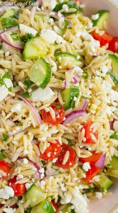 a salad with cucumbers, tomatoes, onions and feta cheese in a white bowl