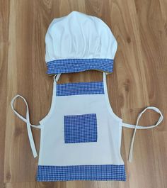 a blue and white apron on the floor with a chef's hat on top