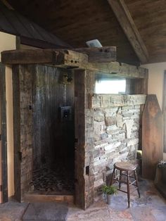 an open door leading into a room with stone walls and flooring, along with a chair