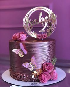 a chocolate cake with pink flowers and butterflies on top is featured in the instagram