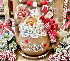 a teapot with some decorations on it sitting in front of candy canes and other candies