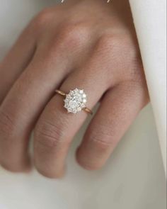 a close up of a person's hand with a diamond ring on their finger