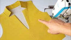 a person using a sewing machine to sew a yellow dress on a mannequin