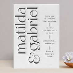 a white greeting card with the word grandma on it next to a small bowl of flowers