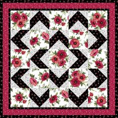 a black and white quilt with red flowers on it's border, in the center