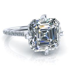 an emerald cut diamond ring with diamonds around it